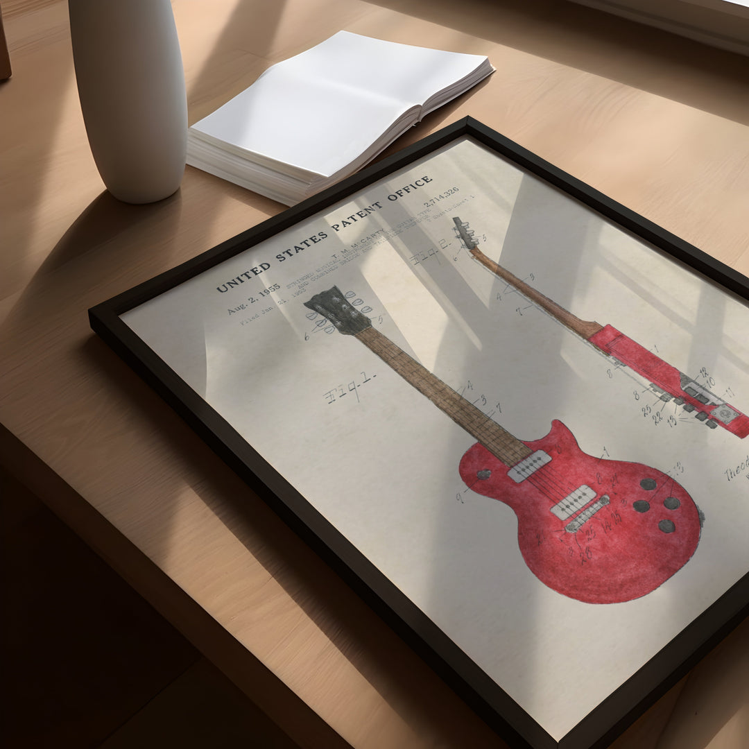 a picture of a red guitar on a table