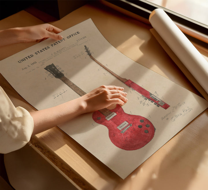 a person is holding a guitar paper on a table