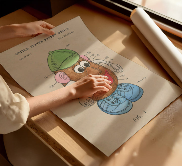 a child's hand on a piece of paper with a drawing of a cartoon