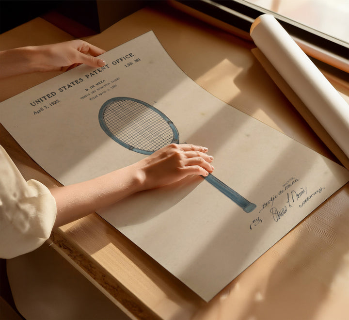 a person holding a tennis racquet on top of a piece of paper