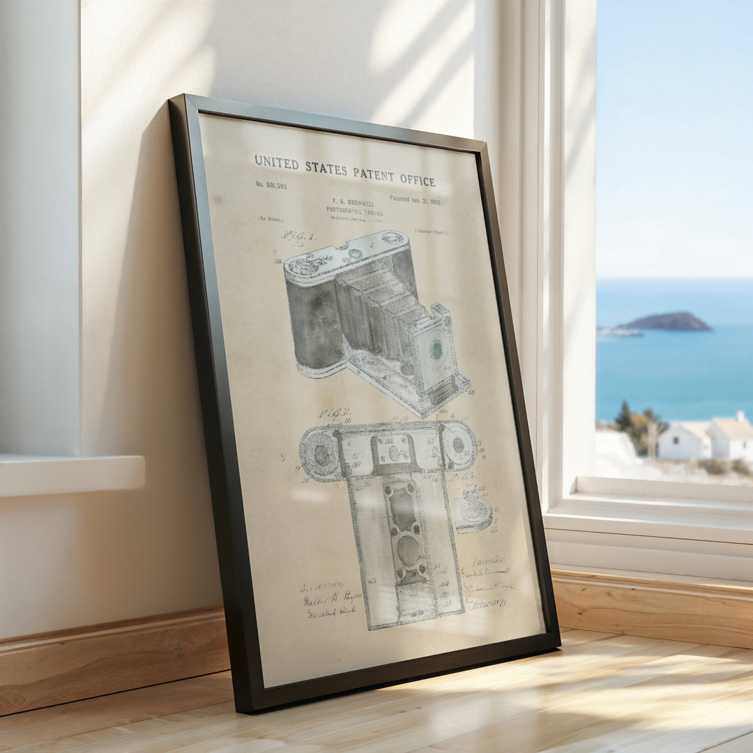 a framed picture of a camera on a window sill