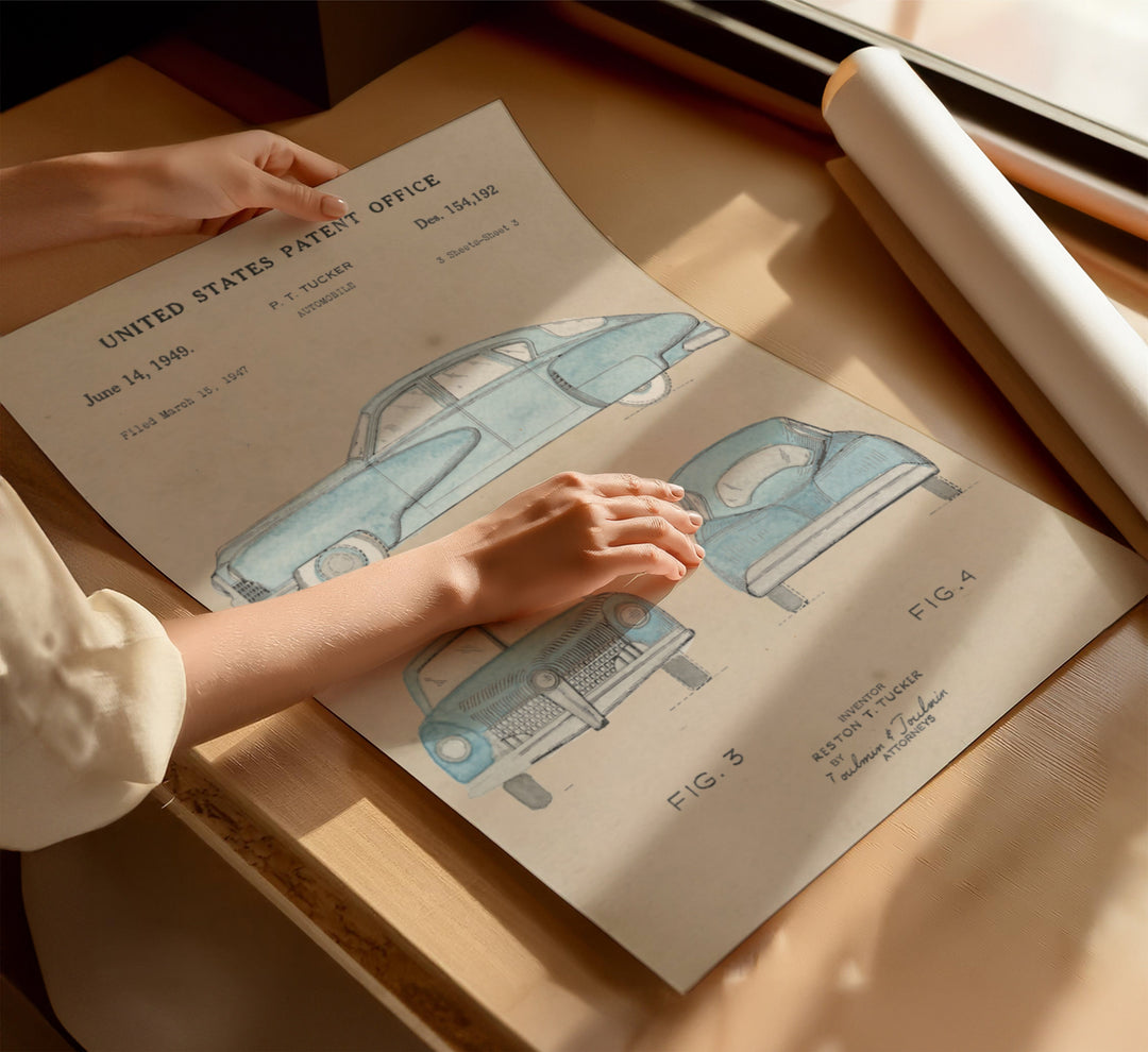 a person's hand on a piece of paper with a drawing of a car